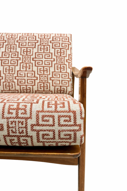 Chair with Greek key patterned cushion on a  neutral background